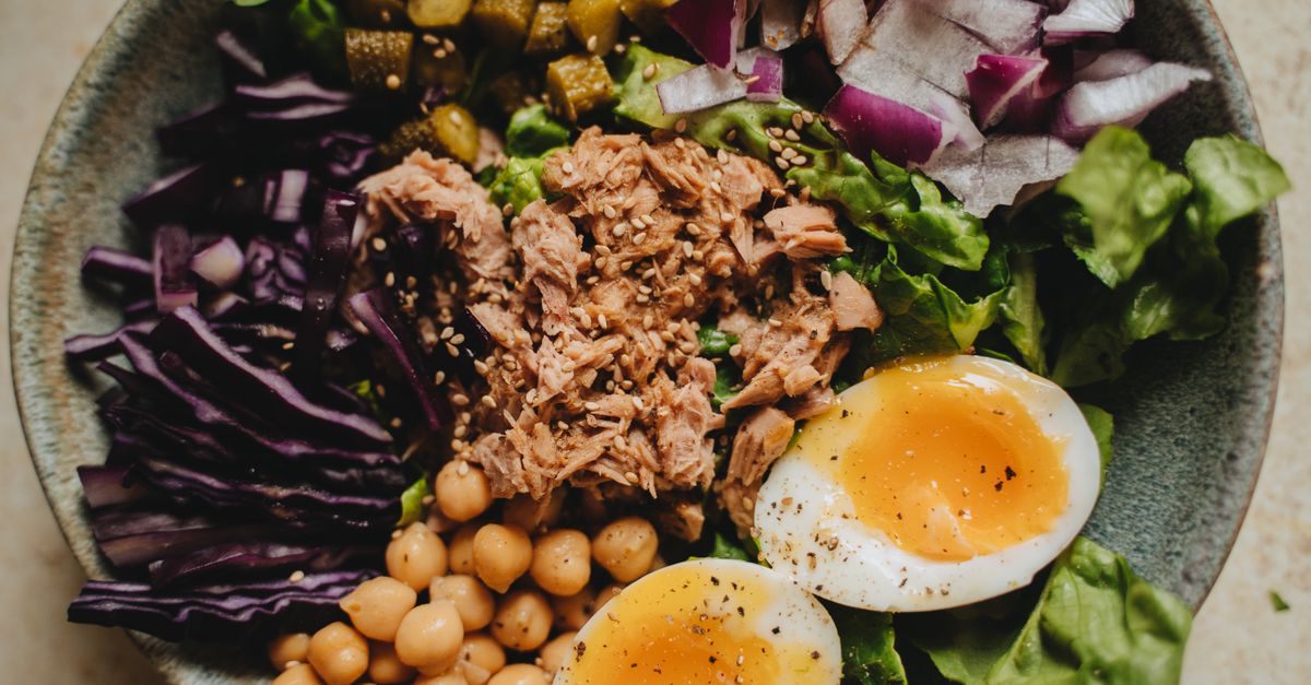 Balanced bowl of tuna, chickpeas, vegetables, and an egg